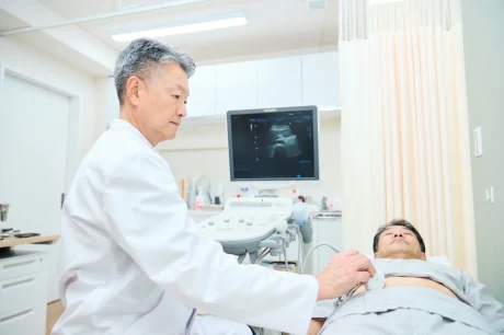 超音波検査機器を使って診察する院長